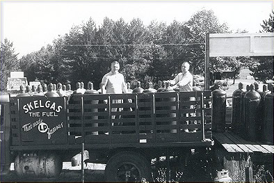 Old photo of employees on a Skelgas Fuel truck with propane tanks